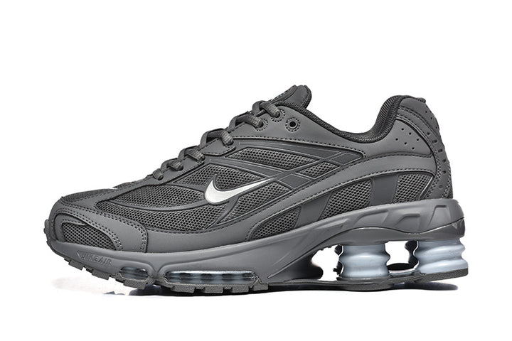 Side view of a dark grey Nike Shox Ride 2 sneaker with visible heel columns