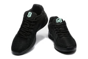 Pair of black low-top Nike basketball sneakers shown from the front and three-quarter angle with mint-green tongue graphics.