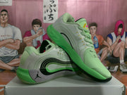Angled view of the pair showing the green upper, black layered side detailing, speckled gray midsole area, and Jordan branding.