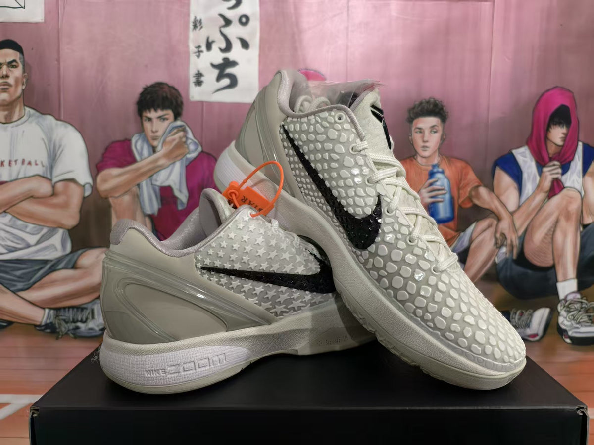 Pair of off-white Nike KD basketball sneakers displayed on a black shoe box, showing the black Swoosh, raised star detailing, and textured forefoot.