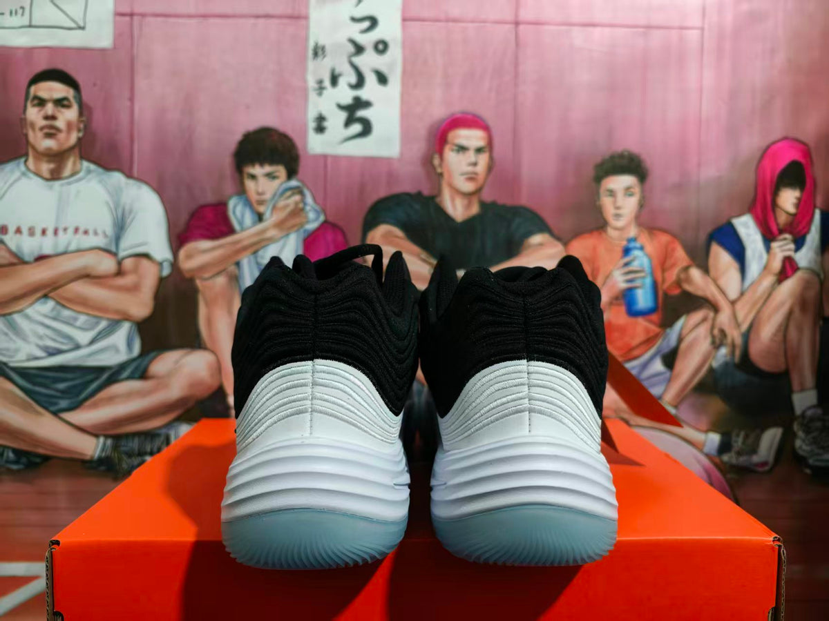 Rear view of black and white Nike basketball sneakers showing layered heel detailing and translucent outsoles.