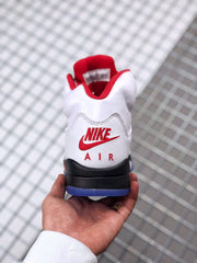 Rear view of the sneaker showing red Nike Air branding, white upper panels, black heel midsole, and blue outsole edge.