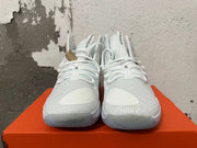 Front view of white Nike basketball shoes with lace-up closures, textured uppers, and gold-tone hanging tag.