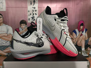 Angled view of the paired white and pink Nike basketball sneakers displaying the side branding and pink outsole.