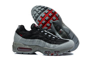 Nike Air Max 95 TT sneakers in black and grey with red outsole accents, shown from the side with the sole visible.
