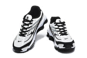 Pair of white and black Nike Shox R4 sneakers shown from the front.