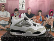 Side profile of a white high-top sneaker with grey overlays, black accents, mesh panels, lace supports, and a visible midsole air window.