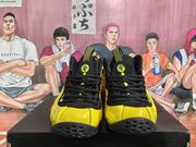 Front view of yellow and black high-top basketball sneakers with black laces