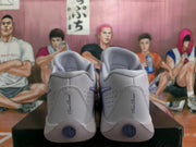 Rear view of lavender and white Nike basketball sneakers showing padded collars, perforated heel panels, and circular heel details.