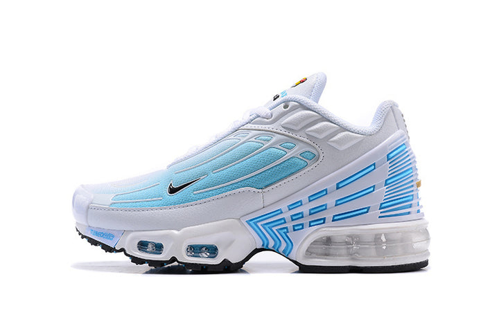Side view of a white Nike sneaker with light blue panels, a black Swoosh, and a clear heel unit.