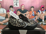 Side view showing the leopard-print upper, star-and-chevron mark, black sole, and 007 accessory detail.
