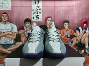 Front view showing white laces, perforated toe panels, gray overlays, and purple rubber outsoles.