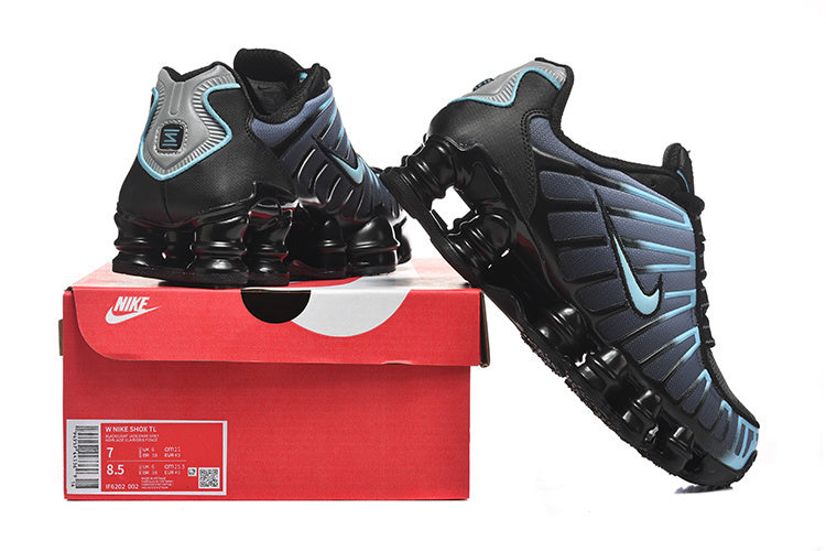 Black and blue Nike Shox TL sneakers displayed on a red shoe box; the box label shows sample size markings.