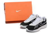 Black and white Nike G.T. Cut Academy shoes displayed beside an orange Nike shoe box.