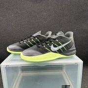 Pair of black and gray low-top sneakers displayed at an angle, highlighting the green accents and side branding.