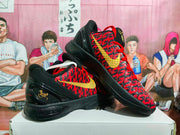 Angled view of the paired sneakers highlighting the gold side swoosh, red laces, black heel structure, and patterned upper.
