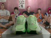 Front view showing the light green toe boxes, matching laces, and contrasting black and gray outsole details.