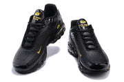 Front views of black Nike Air Max Plus III sneakers with gold accents.