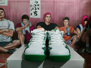Front view of the white and green Nike basketball sneakers showing the laces, toe areas, green outsoles, and upper graphics.