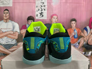 Rear view showing the black heel panels, blue textile uppers, and bright volt collar lining.