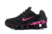Side profile of a black Nike Shox TL sneaker with bright pink accents