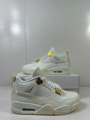 Angled close view of the white Jordan 4 sneaker showing the mesh side panel, molded overlays, and gold accents.