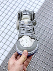 Front view showing the gray laces, perforated white toe box, and branded tongue label.