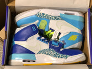 Pair of sneakers arranged inside a shoe box, showing contrasting uppers and yellow outsole details.