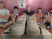 Front view of beige low-top sneakers with tonal laces, layered toe panels, and perforated toe detailing.