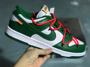 Full angled view of one sneaker showing its white and green upper, red laces, and low-top construction.