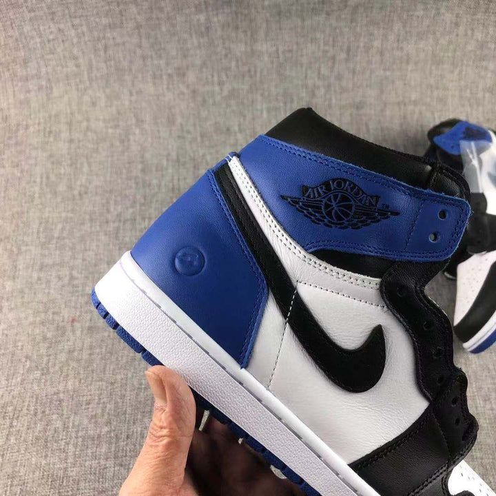 Close-up side view of a black, white, and blue high-top sneaker showing the blue ankle panel, white side panel, black Swoosh, and white midsole.