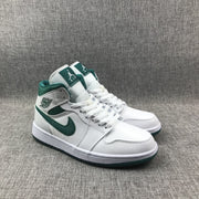 Three-quarter front view of the pair with white laces and green collars.