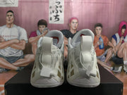Front view of the white Jordan basketball sneakers showing padded collars, tongues, laces, and geometric side panels.