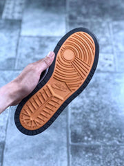 Close view of the orange-and-black outsole with its circular and linear tread pattern.
