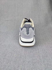Rear view showing the layered grey heel panels, padded collars, white midsoles, and black heel detail.