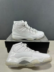 White high-top sneakers shown from the side on a black shoebox, with glossy panels and a translucent outsole.