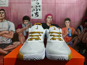 Front view of white Nike Zoom basketball shoes with gold laces and gold outsole accents