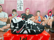Side view highlighting the black, white and red colorway, character artwork, textured outsole, and visible side branding.