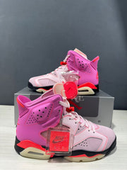 Angled side view of the pink high-top sneakers with a visible heel air unit and red spare laces.