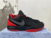 Side view of a black Nike basketball shoe with a dark gray Swoosh and red outsole accents.