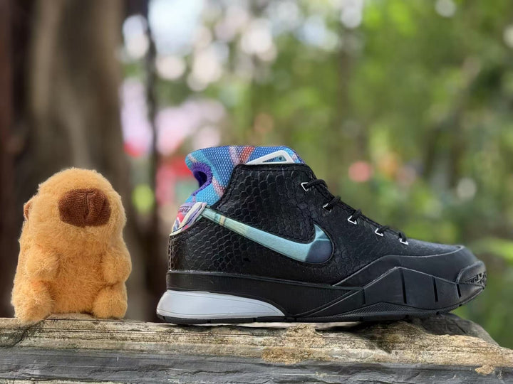Side view of a black kids’ Kobe 1 basketball shoe with a blue accent and colorful collar.