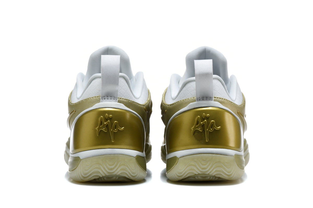 Rear view of white and gold Nike sneakers showing the heel details and outsole.
