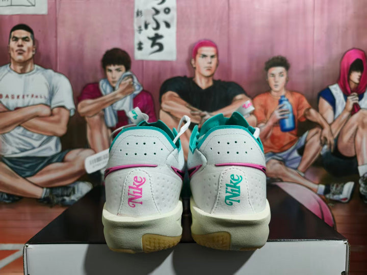 Rear view of white Nike basketball sneakers with turquoise and pink details, displayed on a shoebox.