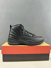 Single black Jordan high-top sneaker shown in side profile on its shoebox.