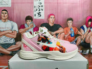 Side view of a pink and off-white Nike basketball sneaker showing painted-style graphics and Zoom branding on the midsole.