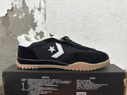 Side view showing the white star-and-chevron emblem on a black Converse sneaker.