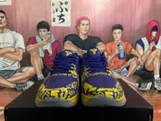 Front view of blue and yellow Nike basketball sneakers showing yellow tongue emblems and graphic forefoot detailing.