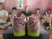 Heel view of pink and white Nike Ja 3 basketball shoes with black Twelve lettering and bright volt outsoles.