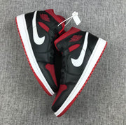 Overhead view of the matching pair showing black uppers, red panels, white Swooshes, and red outsoles.