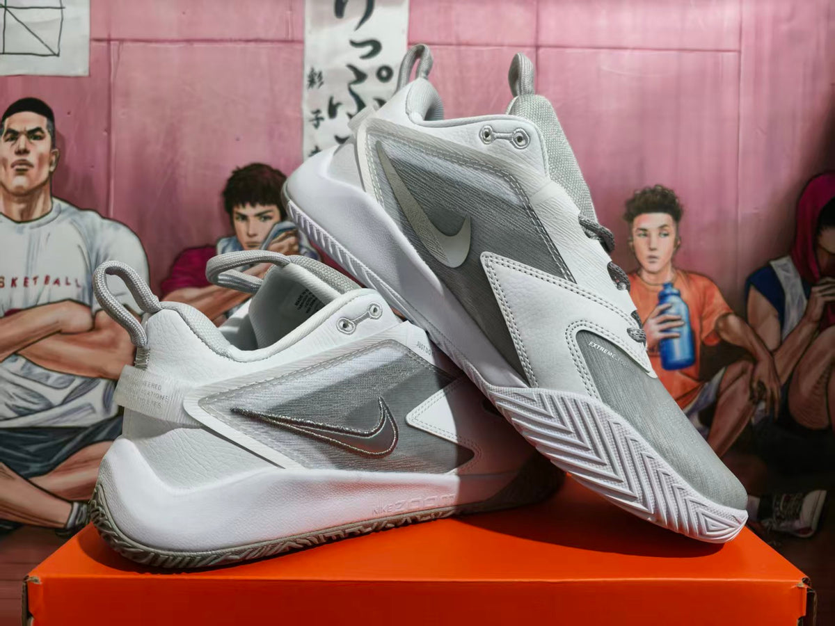 Pair of white and silver Nike basketball shoes shown from the side